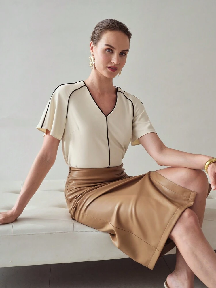 BLUSA COM MANGAS FLUIDAS E DETALHE CONTRASTANTE NO ACABAMENTO