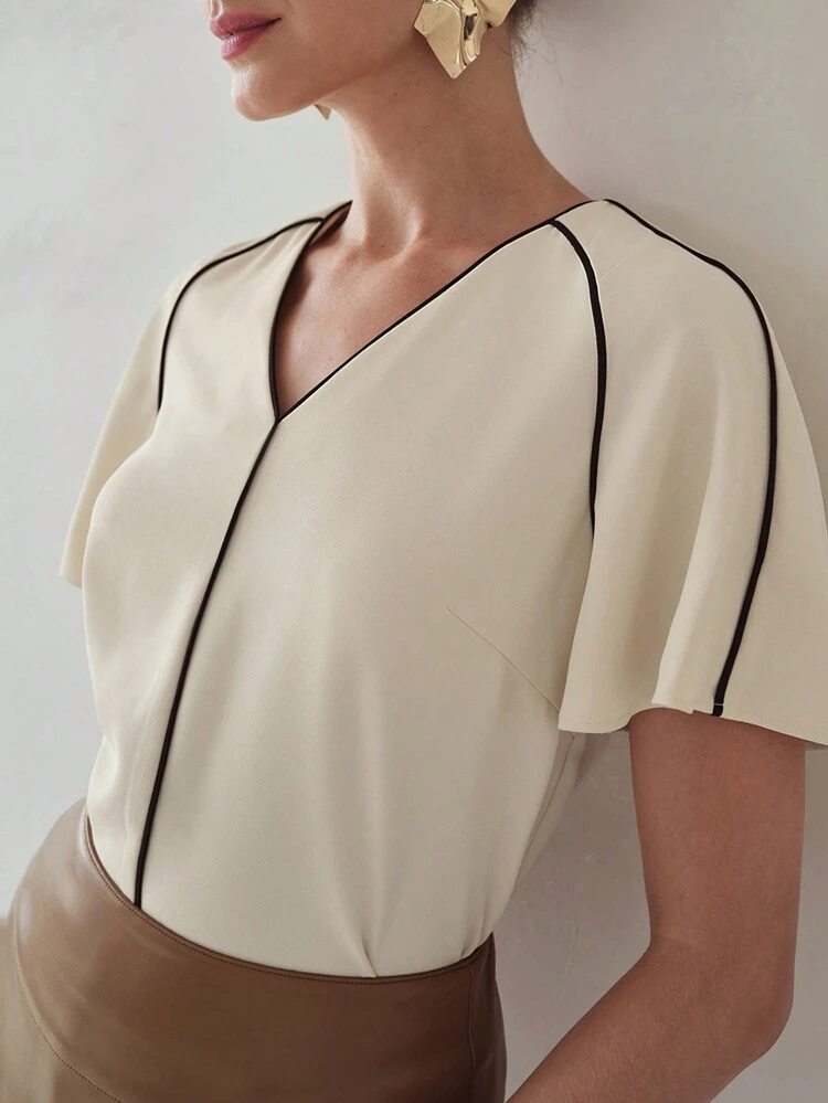 BLUSA COM MANGAS FLUIDAS E DETALHE CONTRASTANTE NO ACABAMENTO