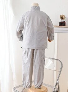 2件/套年轻男童休闲运动薄款前开大口袋风衣外套和多口袋工装裤。外套采用薄款风衣材质，前开半开设计，展现休闲运动风格。带口袋设计的工装裤增添实用性和时尚感。适合年轻男童日常生活穿着，展现休闲舒适的时尚风格。薄款风衣材质使外套轻盈透气，带口袋设计的裤子实用舒适。这套是年轻男童衣橱中实用又时尚的单品，为他们的日常穿着增添时尚休闲的舒适感。