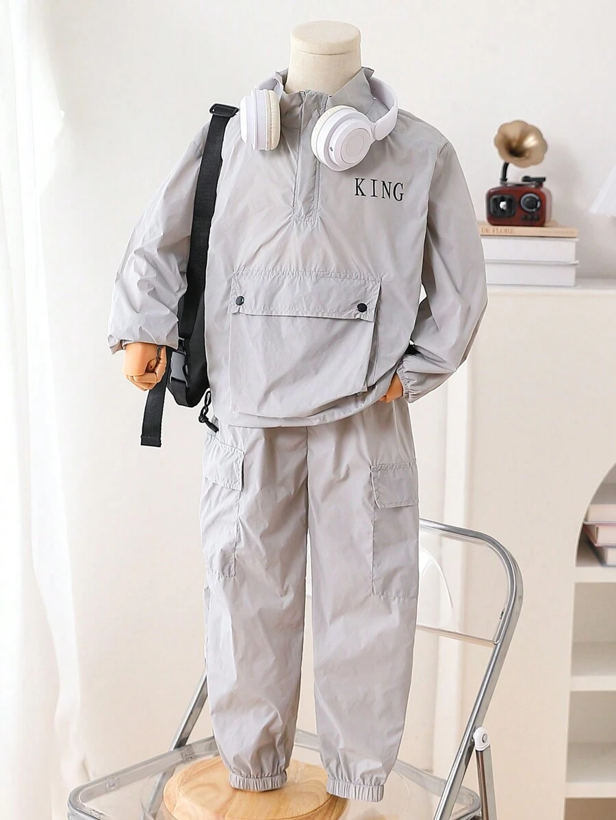 2件/套年轻男童休闲运动薄款前开大口袋风衣外套和多口袋工装裤。外套采用薄款风衣材质，前开半开设计，展现休闲运动风格。带口袋设计的工装裤增添实用性和时尚感。适合年轻男童日常生活穿着，展现休闲舒适的时尚风格。薄款风衣材质使外套轻盈透气，带口袋设计的裤子实用舒适。这套是年轻男童衣橱中实用又时尚的单品，为他们的日常穿着增添时尚休闲的舒适感。