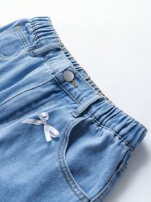 少女不对称设计牛仔裙，带破洞、蝴蝶结和水洗效果