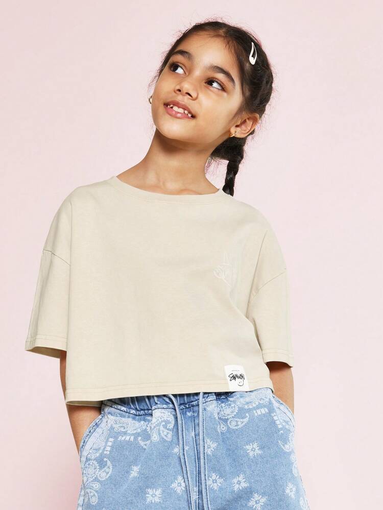 ツイーンガールズ用 洗い加工クロップフィットドロップショルダー Tシャツ グラフィティ&エンジェルプリント付き