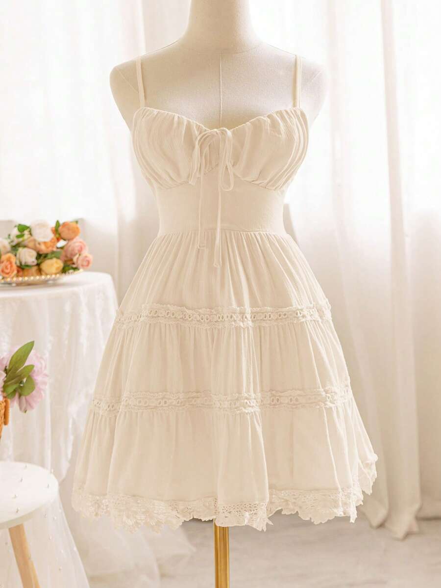 Soleia Vestido mini cami acolchado y plisado en amarillo romántico para vacaciones de verano con espalda abierta, cintura con lazo de corbata y ribete de encaje para mujeres; perfecto para la temporada de bodas - Albaricoque - Ver 1