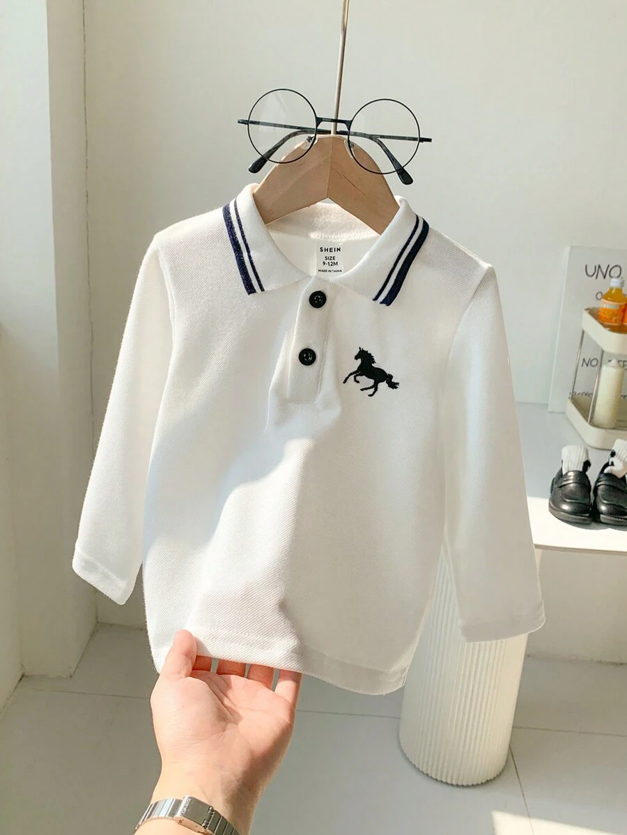SHEIN Playful Pals 这款带刺绣图案的男婴 Polo 领 T 恤将经典 Polo 衫设计与时尚活泼的刺绣图案相结合，是宝宝衣柜中的理想单品。它具有 Polo 衫的经典优雅，同时添加了有趣的刺绣元素，让您的小宝贝看起来既可爱又时尚。衣领有两个纽扣，方便穿着，更时尚。