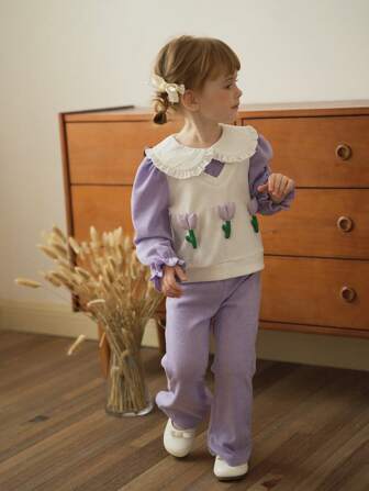 SHEIN Vintaside Kids Ensemble deux pièces à imprimé floral de tulipe violette à manches longues pour jeune fille. La tenue présente un schéma de couleurs violet élégant et doux, avec un col arrondi sur le Top qui contraste magnifiquement. Le motif floral 3D sur la poitrine ajoute une touche vivante et dynamique. Le pantalon évasé aide à mettre en valeur la ligne de la jambe avec une touche rétro chic. Convient pour le port quotidien casual, les activités extérieures et les saisons de printemps/automne.