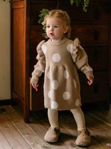 Váy len cổ tròn bèo nhún chấm bi bằng vải Jacquard cho bé gái. Thiết kế chấm bi mang đến nét vui tươi và thời trang, trong khi các chi tiết vải Jacquard mềm mại vô cùng quyến rũ. Thiết kế viền bèo nhún thanh lịch và hấp dẫn, toát lên vẻ duyên dáng. Váy len cổ tròn phù hợp với mùa Thu/Đông, mang đến sự ấm áp và thoải mái. Thích hợp cho các buổi đi chơi, giữ ấm cho bé gái và đáng yêu khi đi du lịch. Chiếc váy này không chỉ tràn đầy sự ngây thơ và dễ thương của trẻ thơ mà còn tạo ra một môi trường ngọt ngào và ấm áp cho bé gái, giúp bé tỏa sáng sự vui tươi và tràn đầy sức sống trong các buổi đi chơi Thu/Đông. - Màu Khaki - Xem 1