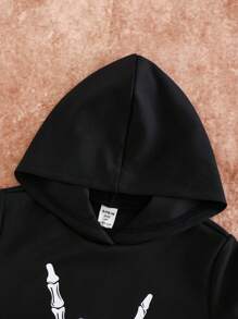 SHEIN Conjunto de 2 piezas para niños pequeños: Sudadera con capucha negra con gráfico de mano de esqueleto blanca y vaqueros grises skinny de mezclilla desgastados y rasgados, outfit de ropa de otoño/invierno para niños pequeños