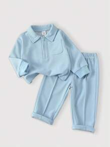 SHEIN Playful Pals Bộ thời trang cho bé trai mùa xuân/thu, màu sắc ấm áp được lựa chọn cẩn thận, thể hiện phong cách thanh lịch đơn giản. Ấm áp và thoải mái, phù hợp với mùa hơi lạnh. Áo dài tay cổ khóa kéo nửa màu trơn, thiết kế chui đầu dễ mặc; kết hợp với quần dài không cạp chun màu trơn, tổng thể đồng bộ. Cho dù đi dạo, mặc ở nhà thường ngày, tập thể dục nhẹ nhàng hay tụ họp gia đình ấm cúng, bộ đồ này sẽ giúp bé toát lên vẻ ngây thơ và sức sống như trẻ thơ, trở thành tâm điểm chú ý. - Màu xanh lam - Xem 1