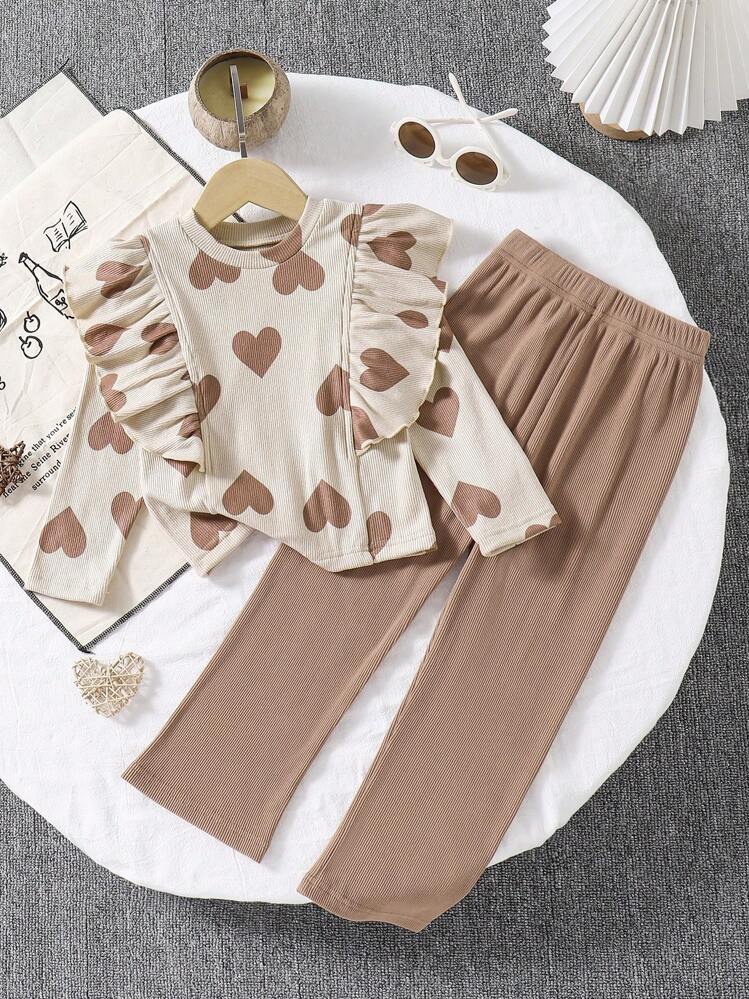 SHEIN 可爱少女针织两件套，心形图案设计。这款柔软舒适的服装采用温暖的米色，饰有心形细节，增添舒适可爱的外观。褶皱肩部设计增添时尚气息。这款套装采用舒适的针织面料制成，非常适合女孩秋冬季穿着，无论居家还是户外，都能展现她们甜美可爱的风格。 - 杏色 - 查看 1