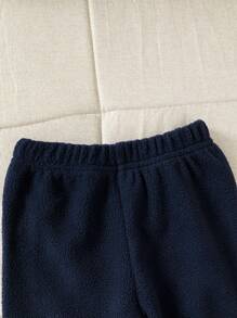 SHEIN Ensemble deux pièces à la mode et cool pour bébé garçon en hiver, comprenant un sweat-shirt tricoté multicolore avec fermeture à glissière et un pantalon de jogging noir.