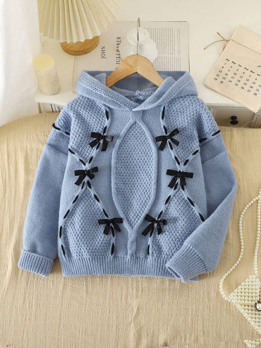 SHEIN 秋冬季少女毛衣,全新设计,黑色 3D 蝴蝶结和线条图案装饰,彰显优雅与时尚。柔软的卡其色面料,穿着舒适保暖。连帽宽松设计增添街头风,宽松廓形营造出层次感和立体感,展现精致工艺。适合居家、外出、度假、家庭聚会。活泼可爱,可搭配连衣裙或裤子,打造不同的时尚造型。 - 霧霾藍 - 查看 1