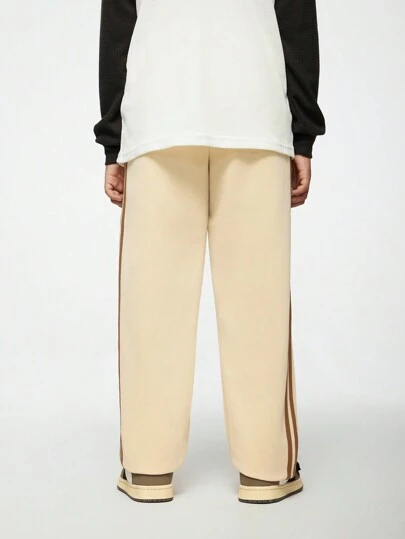 SHEIN Explorewe 1 قطعة بنطلون سكيت بورد كاجوال فضفاض مستقيم بلون الخاكي للأولاد المراهقين مع خطوط منسوجة بنية على الجانب، تصميم ساق مستقيمة عالية الخصر يجمل الشكل ويطيل الساقين. خصر مطاطي للارتداء السهل، مناسب لمناسبات متنوعة مثل الخروجات اليومية والرياضة الترفيهية أو التجمعات، ويمكن تنسيقه مع أنواع مختلفة من الأعلى لإظهار أسلوبك المتنوع وجاذبيتك الفريدة.