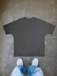 Manfinity EMRG Men's Young Street - Style INS Best - Selling T - Shirt. It Is In A Dark Tone, With The Main Body Being Dark Gray. There Is A White Pattern Printed On The Front Of The T - Shirt. The Pattern Depicts A Group Of People Standing In Front Of A Building. The People Have Various Postures, And There Are Elements Such As Clouds In The Background. The Overall Look Presents A Street Style.