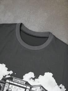 Manfinity EMRG Men's Young Street - Style INS Best - Selling T - Shirt. It Is In A Dark Tone, With The Main Body Being Dark Gray. There Is A White Pattern Printed On The Front Of The T - Shirt. The Pattern Depicts A Group Of People Standing In Front Of A Building. The People Have Various Postures, And There Are Elements Such As Clouds In The Background. The Overall Look Presents A Street Style.