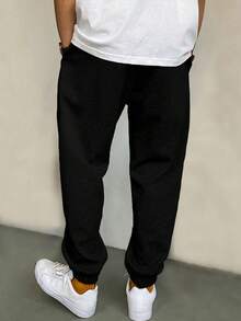 EURMUSE Bawełniane męskie spodnie dresowe ze ściągaczem w pasie i napisem graficznym - Czarne - Zobacz 2