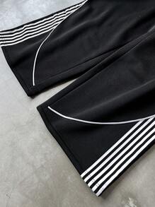 Manfinity Sporsity Men's Streetwear Academy INS Black Sweatpants With White Striped Color Block Design, Men's Striped Drawstring Waist Loose Fit Athletic Style Casual Sweatpants,Men's Black Sports Pants With Streamlined White Stripes And Red Letter Logo, Simple And Neat Design, Full Of Sporty Feeling. Suitable For Outdoor Sports And Leisure Occasions.