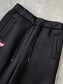 Manfinity Sporsity Men's Streetwear Academy INS Black Sweatpants With White Striped Color Block Design, Men's Striped Drawstring Waist Loose Fit Athletic Style Casual Sweatpants,Men's Black Sports Pants With Streamlined White Stripes And Red Letter Logo, Simple And Neat Design, Full Of Sporty Feeling. Suitable For Outdoor Sports And Leisure Occasions.