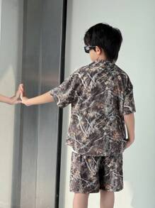 SHEIN 2 pièces Ensemble de chemise à manches courtes ample et shorts pour garçons pré-adolescents, imprimé feuilles, col polo, ouverture devant. Convient pour l'école, le jardin, la plage, l'anniversaire, le printemps, l'été, l'automne et l'hiver