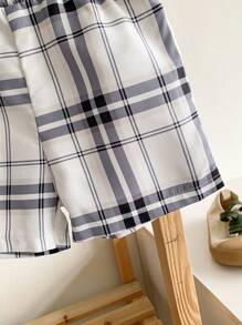 Souflis Souflis 2-częściowy zestaw dla chłopca/niemowlęcia: bluzka z kołnierzykiem i krótkim rękawem w połączeniu ze spodniami w kratę. Bluzka z kołnierzykiem ma minimalistyczny nadrukowany wzór, który zapewnia stylowy wygląd, odpowiedni na wszystkie letnie okazje.