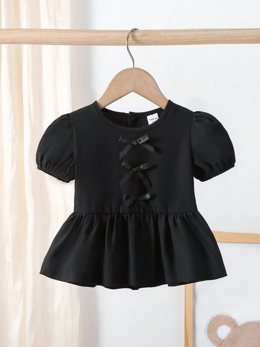 SHEIN 夏季女宝宝甜美优雅黑色泡泡袖短袖上衣，正面精致3D蝴蝶结，增添一丝精致俏皮感。搭配褶皱下摆设计，展现层次感和效果。适合多种场合，无论是约会、逛街、居家休闲还是朋友聚会。