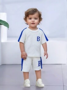 SHEIN 2 pièces Ensemble bébé garçon, nouveau t-shirt à manches courtes et short en tricot d'été à rayures à bulles minimaliste avec broderie lettres et couleurs contrastées, col rond, manches raglan. Combinaison de couleurs décontracté, broderie de lettre unique, tout-aller polyvalent, convient pour l'été, motif délicat, assortiment d'été, vêtements de sport, vacances, vêtements de jeu, tenue scolaire, tout-petit, unisexe, été - Blanc - Voir 1