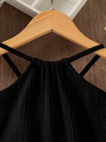 SHEIN 年轻女孩休闲时尚梭织纹理面料流苏下摆挂脖连衣裙。梭织纹理面料为连衣裙增添了高品质的感觉和优雅的设计。流苏下摆设计增添了动感和优雅的感觉，展现了年轻女孩的活泼个性。挂脖设计增添了休闲感，适合春夏穿着，适合各种场合，优雅时尚，打造清新时尚的整体造型，展现年轻女孩的独特魅力。 - 黑色 - 查看 4