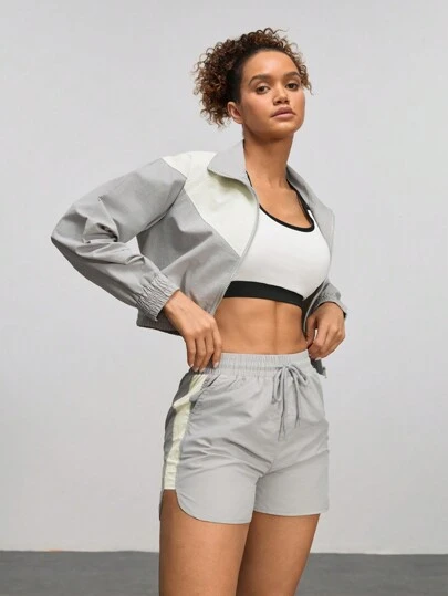 Conjunto de ropa de exterior con parte superior de manga larga y cremallera delantera y pantalones cortos en color liso y diseño de patchwork para mujer