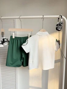 SHEIN 2 件装 年轻男孩休闲运动学院风文艺复古街头宽松涂鸦翻领衬衫和工装短裤套装 适合年轻男孩服装 年轻男孩服装 返校男孩套装 适合生日派对、晚会、表演、婚礼、洗礼、开幕式 适合服装 适合日常使用 适合上学 适合旅行 适合运动 适合春夏季