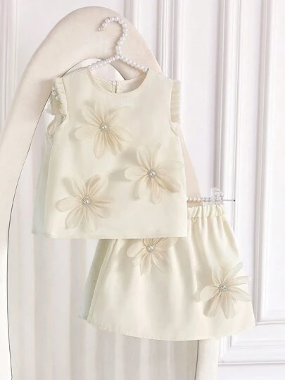 2 件套小女孩纯色荷叶边领背心和 3D 花朵 A 字裙，采用优质面料制成，带有 3D 花卉装饰，适合户外玩耍、室内休闲、轻度运动和派对，让小女孩成为关注的焦点