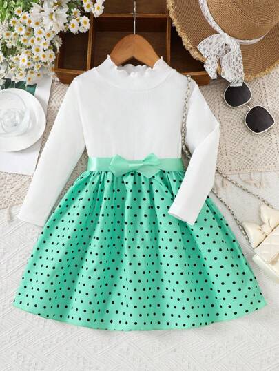 Vestido tejido de parches con lunares verdes para niña, una prenda esencial de moda para otoño, invierno y primavera. La combinación ingeniosa de tejido de punto y tejido proporciona un aspecto suave pero sofisticado. El diseño de mangas largas permite a la pequeña usarlo con zapatos o zapatillas, mostrando un único en diferentes ocasiones. Los adorables elementos de lunares verdes añaden un toque refrescante y animado, expresando plenamente la dulzura infantil.