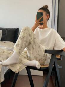 Livesso Conjunto de pijama con top de camiseta holgada de unicolor y pantalones estampados con dibujos florales de líneas en todo el diseño