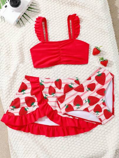 SHEIN Conjunto de traje de baño para niña de 4 piezas, incluye top con tirantes de espagueti, shorts, falda cubresol y sombrero para la playa. Novedad para primavera/verano. Perfecto para el Día de San Valentín. El adorable estampado de fresa hace que las niñas se vean talla grande lindas, con volantes para un look dulce y encantador.