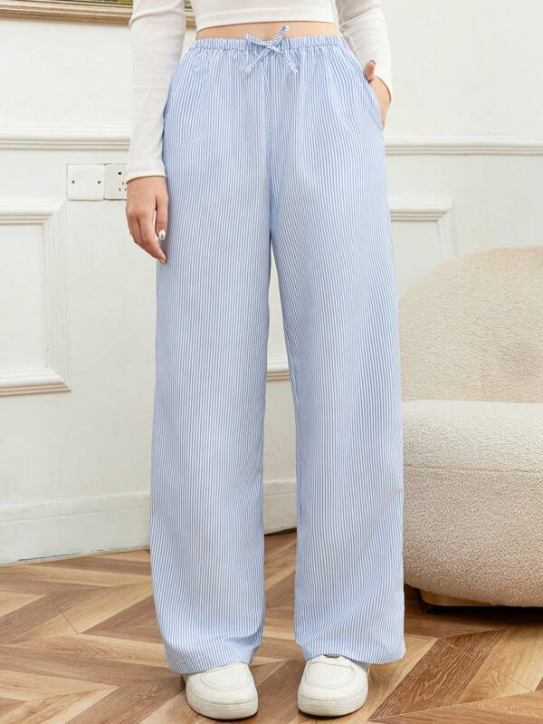 Pantalones casuales holgados y a rayas para adolescentes, que aportan una sensación diferente de ocio y bienestar, con una silueta ancha y casual, que cuelga con gracia en los pies, mostrando un ambiente cómodo.