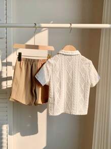 SHEIN Set informal de 2 piezas para niños pequeños, estilo universitario - Suéter de punto suave de cuello redondo de color blanco sólido con diseño calado y pantalones cortos cómodos con dobladillo en contraste color caqui, adecuado para primavera y verano, uso diario, escuela, viajes, vacaciones y fiestas