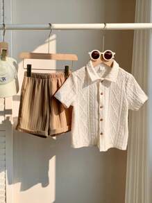 SHEIN Set informal de 2 piezas para niños pequeños, estilo universitario - Suéter de punto suave de cuello redondo de color blanco sólido con diseño calado y pantalones cortos cómodos con dobladillo en contraste color caqui, adecuado para primavera y verano, uso diario, escuela, viajes, vacaciones y fiestas