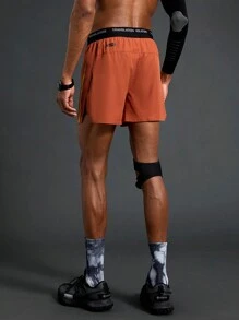 Manfinity Sport Polished Shorts esportivos com fenda lateral e cós em bloco de cores masculino