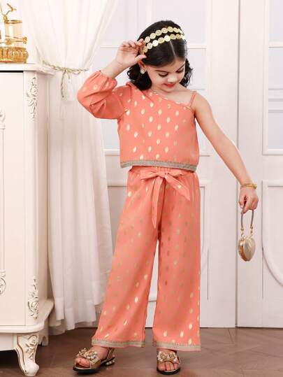 SHEIN Conjunto de 2 piezas para niñas jóvenes: Top de color coral rosa con tela metalizada, hombro asimétrico, manga larga, bajo ribeteado con cinta bordada dorada; emparejado con pantalón largo de pierna recta holgada con tela metalizada y cinturón. Elegante, apropiado para la escuela, salidas, reuniones familiares, Ramadán, primavera/otoño