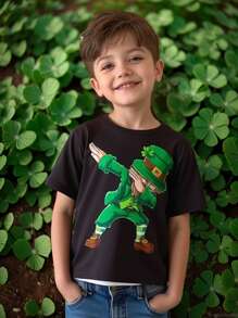 Camiseta verde para niño pequeño con estampado de niño de trébol de cuatro hojas. Esta camiseta verde para niños pequeños presenta un color base verde fresco, que muestra el vigor y la vitalidad de las estaciones de primavera y verano. El frente muestra una impresión alegre de un niño con trébol de cuatro hojas, que simboliza la buena suerte y la felicidad.