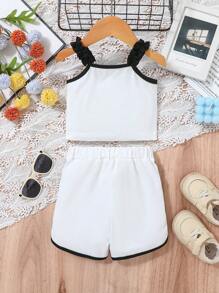 Baby Girl Casual Sports-Inspired Fashion Outfit, Black & White Color Block Design. Ruffled Shoulder Strap Top With "Baby Girl" Print, Paired With Loose White Shorts With Black Contrast Trim. Accented With Black Bowknot At Waist, Suitable For Everyday Wear, Family Gatherings And Relaxed Outdoor Activities.