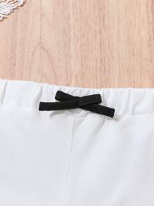 Baby Girl Casual Sports-Inspired Fashion Outfit, Black & White Color Block Design. Ruffled Shoulder Strap Top With "Baby Girl" Print, Paired With Loose White Shorts With Black Contrast Trim. Accented With Black Bowknot At Waist, Suitable For Everyday Wear, Family Gatherings And Relaxed Outdoor Activities.