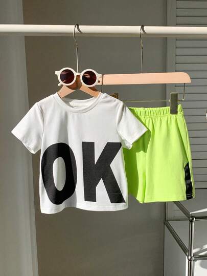 SHEIN 2pcs Baby Boy/Girl Casual Sports Streetwear Cute Holiday OK Letter Print Round Neck Short Sleeve White T-Shirt And Neon Green Shorts Set, Suitable For Daily Wear, Traveling, Sports, Spring/Summer