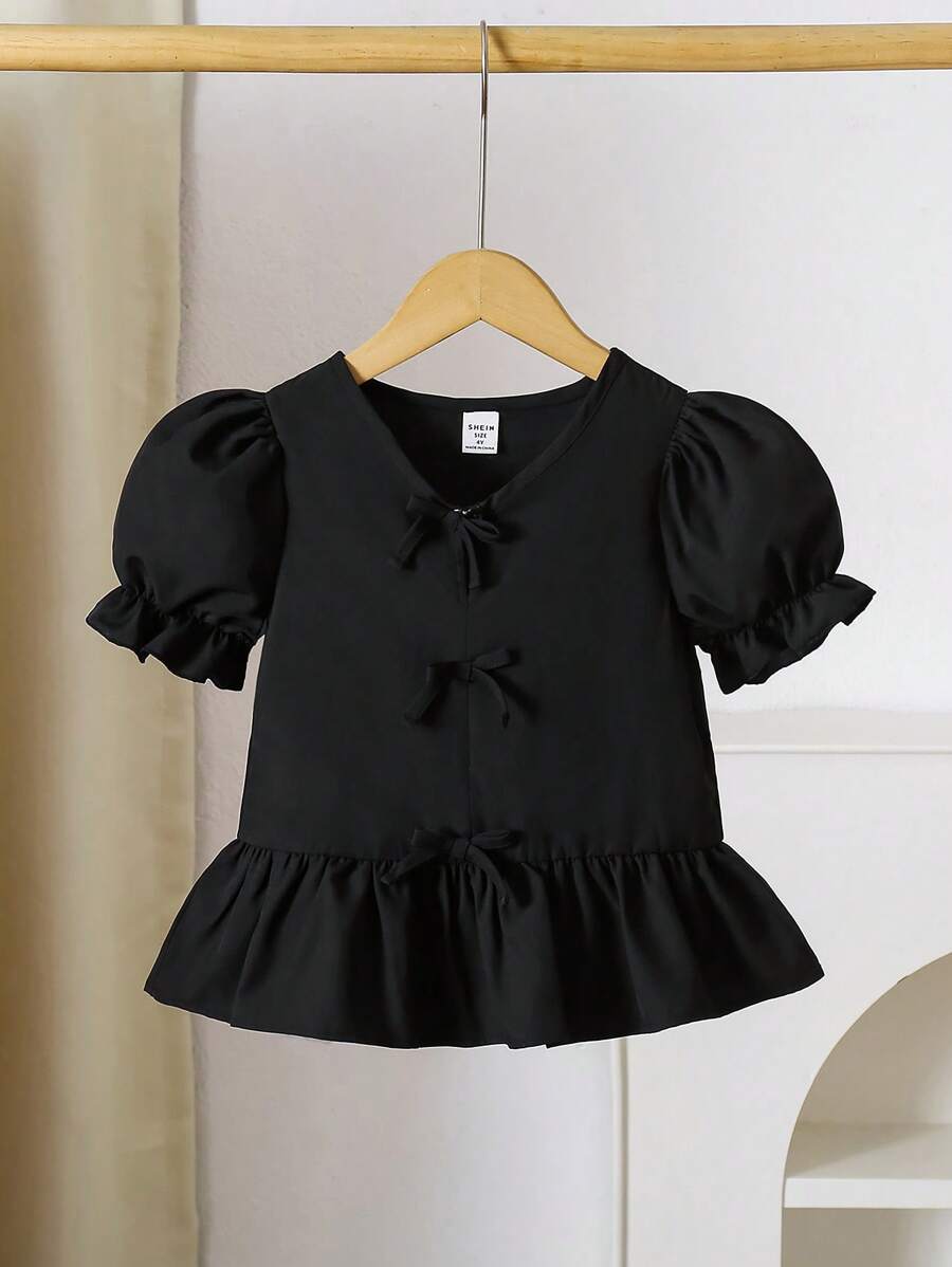 Blusa para niña con cuello en V, mangas abullonadas, volantes en el bajo y decoración de moño