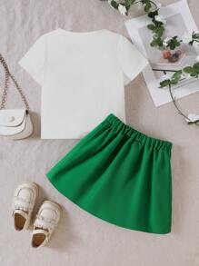 Set de 2 piezas de conjunto informal y lindo para niñas pequeñas, que incluye una blusa de punto de manga corta con cuello redondo y estampado de trébol para la primavera/verano, y una falda plisada de línea A de color liso