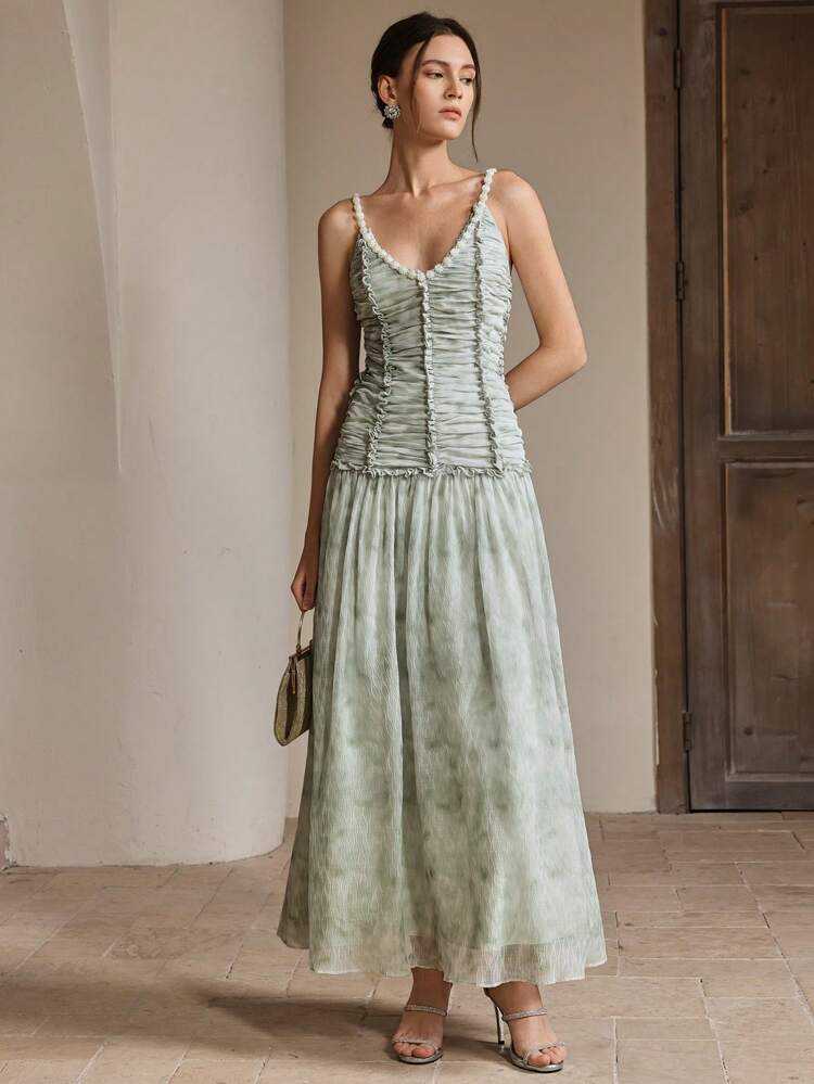 Robe de soirée élégante et romantique avec dos nu, bretelles de perles, décolleté en V, volants à l'ourlet, texture. Tenues printanières et estivales pour femmes