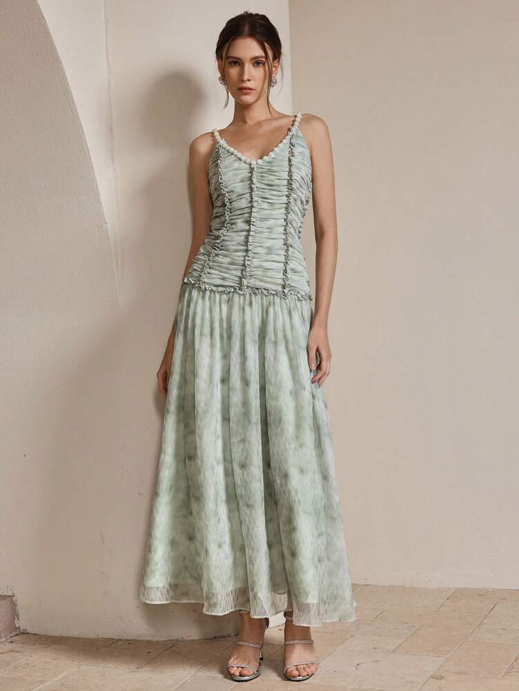 Robe de soirée élégante et romantique avec dos nu, bretelles de perles, décolleté en V, volants à l'ourlet, texture. Tenues printanières et estivales pour femmes