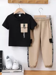 SHEIN 2 piezas Conjunto informal deportivo para niño pequeño - Camiseta negra de cuello redondo de manga corta con bolsillo de color contrastante y cinta con texto, combinada con pantalones cargo de cintura elástica, adecuado para juegos diarios al aire libre, escuela, deportes, viajes, primavera y verano