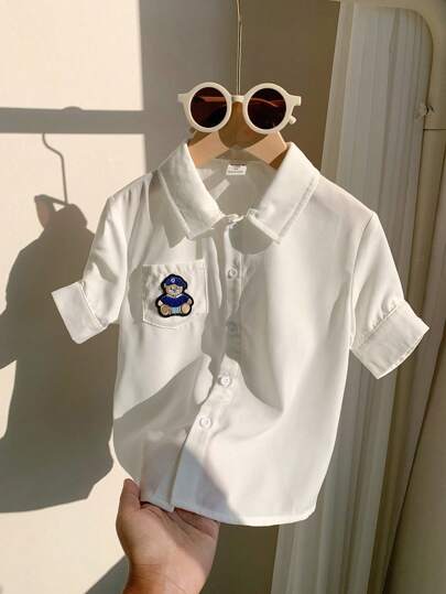 SHEIN Leap Crew 男童可爱小熊动物图案短袖衬衫，袖口口袋翻领设计，纯色百搭，适合儿童穿着，也适合返校季穿着，可用于生日派对、聚会、演出、婚礼、洗礼、开学典礼、日常穿着、校服、旅行、运动以及春夏季节。