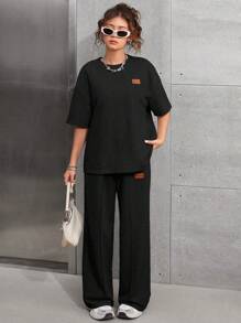 SHEIN Set casual da 2 pezzi per ragazze adolescenti - Maglia nera a maniche raglan, girocollo, con applicazione, spalle scoperte e pantaloncini sportivi