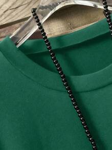 Camiseta holgada de mujer talla grande con cuello redondo, manga corta y bajo asimétrico en color liso