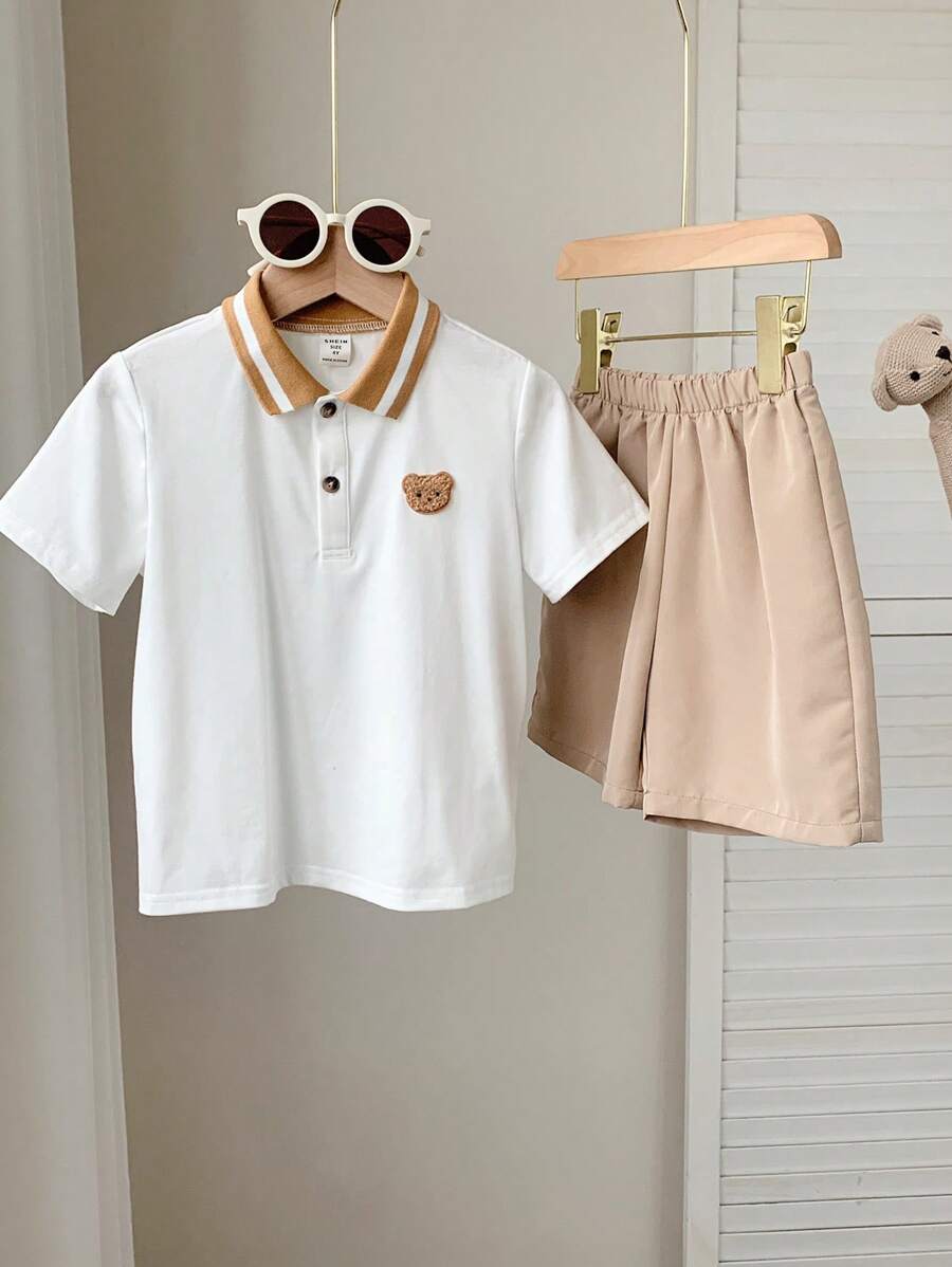 SHEIN 2pcs Toddler Boys Cute Academia Casual Cartoon Hand-Painted Teddy, Letter Embroidery Pattern Round Neck Short Sleeve White Knit Polo Shirt And Elastic Waist Khaki Comfortable Woven Shorts Set, Suitable For Outings, Home, Easter, Party, School, Vacation, Sports, Spring/Summer
